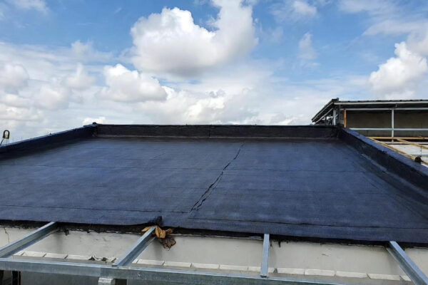 A flat roof with installed waterproof roofing membrane, showing proper sealing and preparation for long-term weather protection.